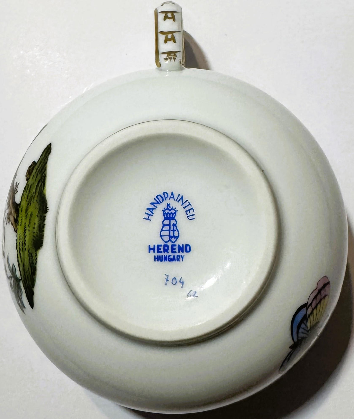 Bottom of white porcelain teacup showing "Handpainted Herend Hungary" mark with shield logo anddecorated with pa