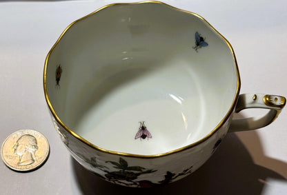 Herend porcelain teacup with hand-painted birds and insects, gold rim, shown next to quarter for scale