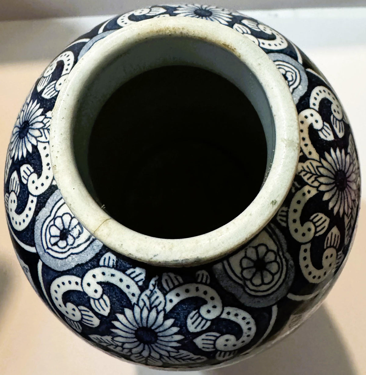 Blue and white ceramic vase with floral and scrollwork decoration, photographed from above showing the open rim and interior 