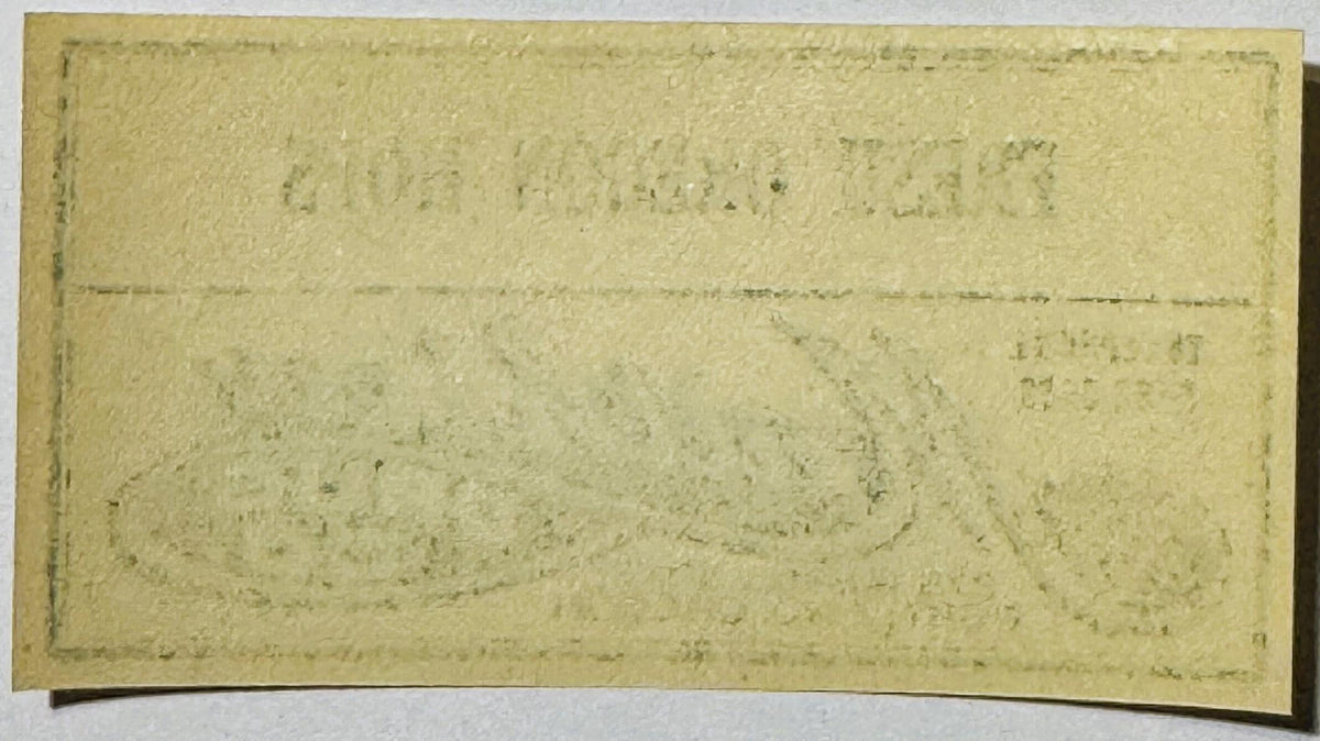 Aged cream-colored rectangular label with faded printed text and horizontal fold lines, photographed flat against white backg