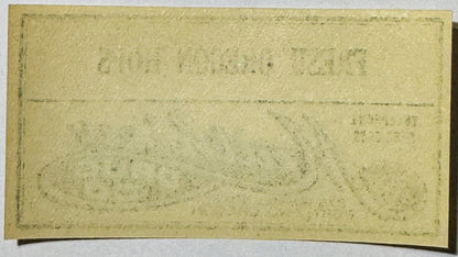 Aged cream-colored rectangular label with faded printed text and horizontal fold lines, photographed flat against white backg