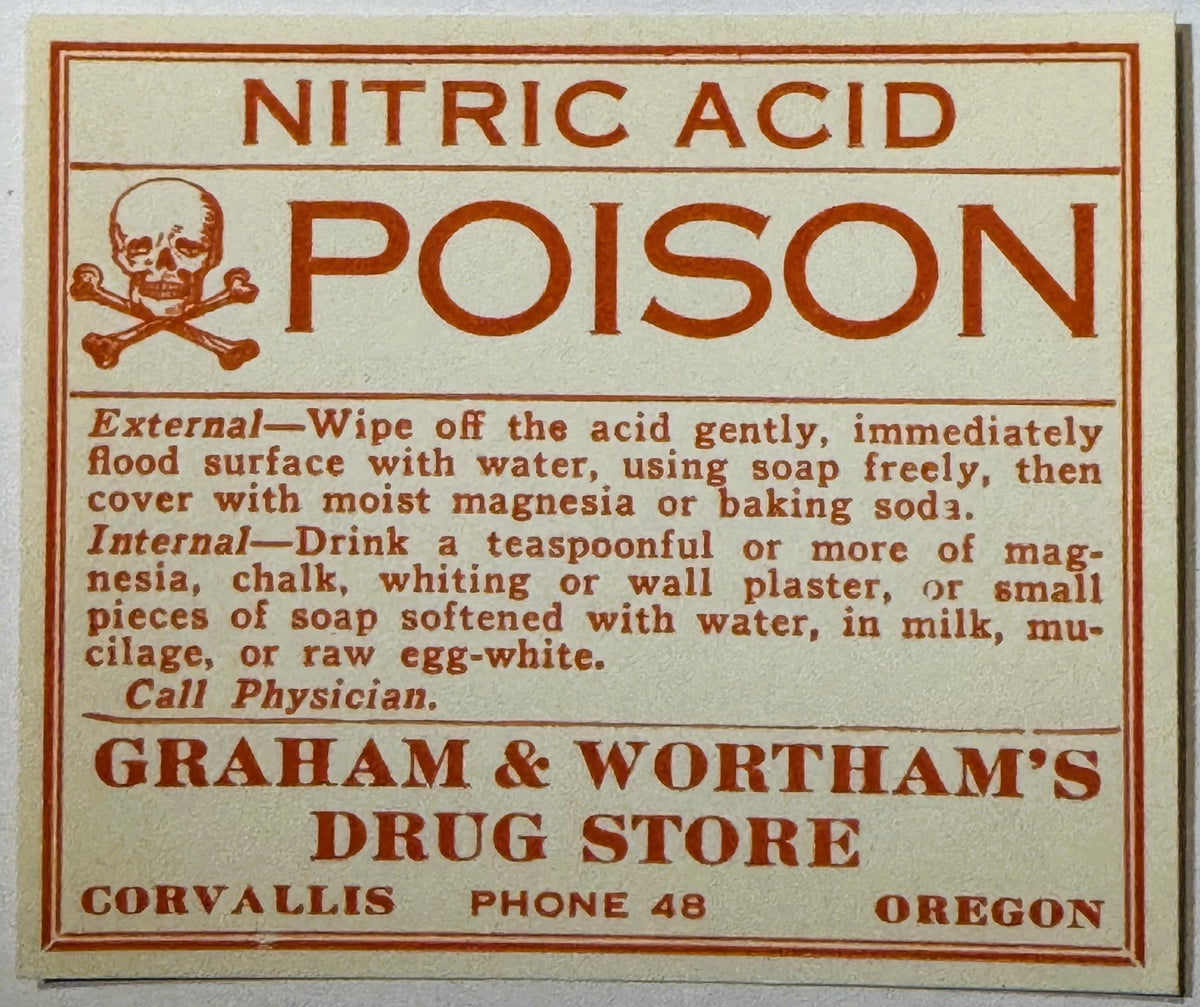 Vintage nitric acid poison warning label with skull and crossbones, red text on cream background, Graham & Wortham's Drug Sto