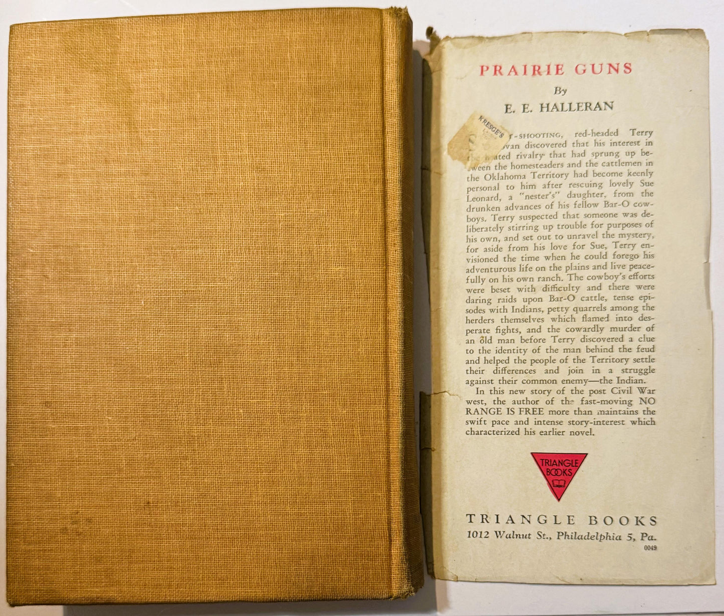 Open vintage hardcover book with gold cloth spine and cream interior page showing "Prairie Guns" title and publisher details 