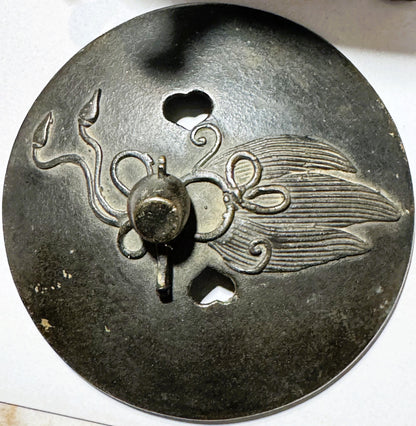 Close-up of ornate bronze censer lid showing embossed dragon head with curled horns, decorative loops, and feathered wing det