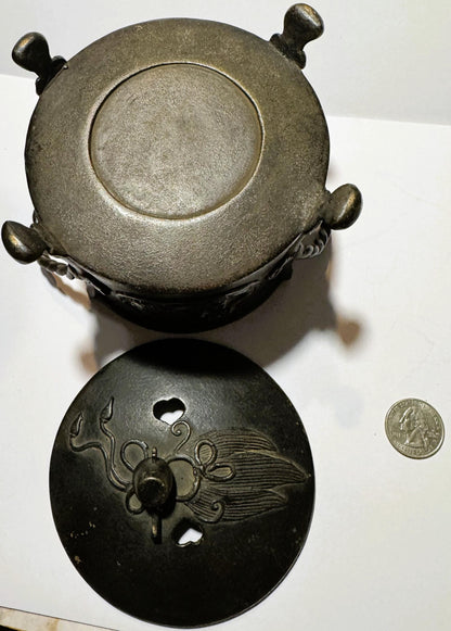 Antique bronze censer disassembled showing lidded top with finials and decorative base with dragon motif, quarter coin for sc