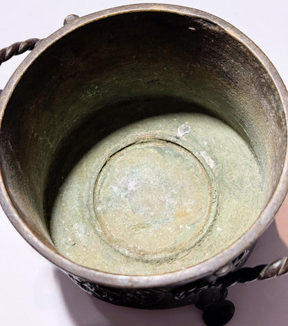 Interior overhead view of antique bronze censer showing patina-covered base with concentric circular markings and dark oxidiz