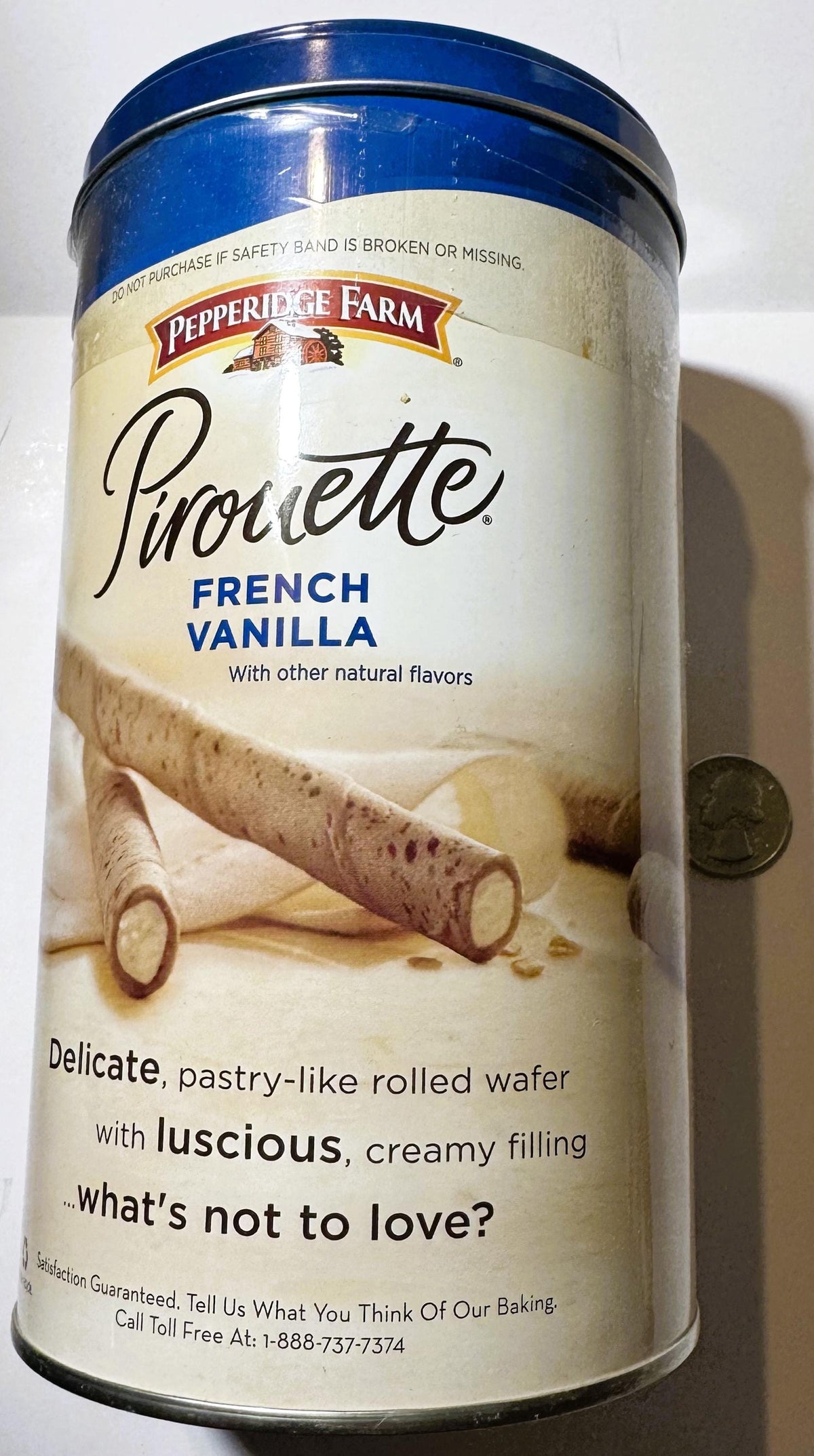 Pepperidge Farm Pirouette French Vanilla tin with blue lid and cream label, displayed next to a coin for scale