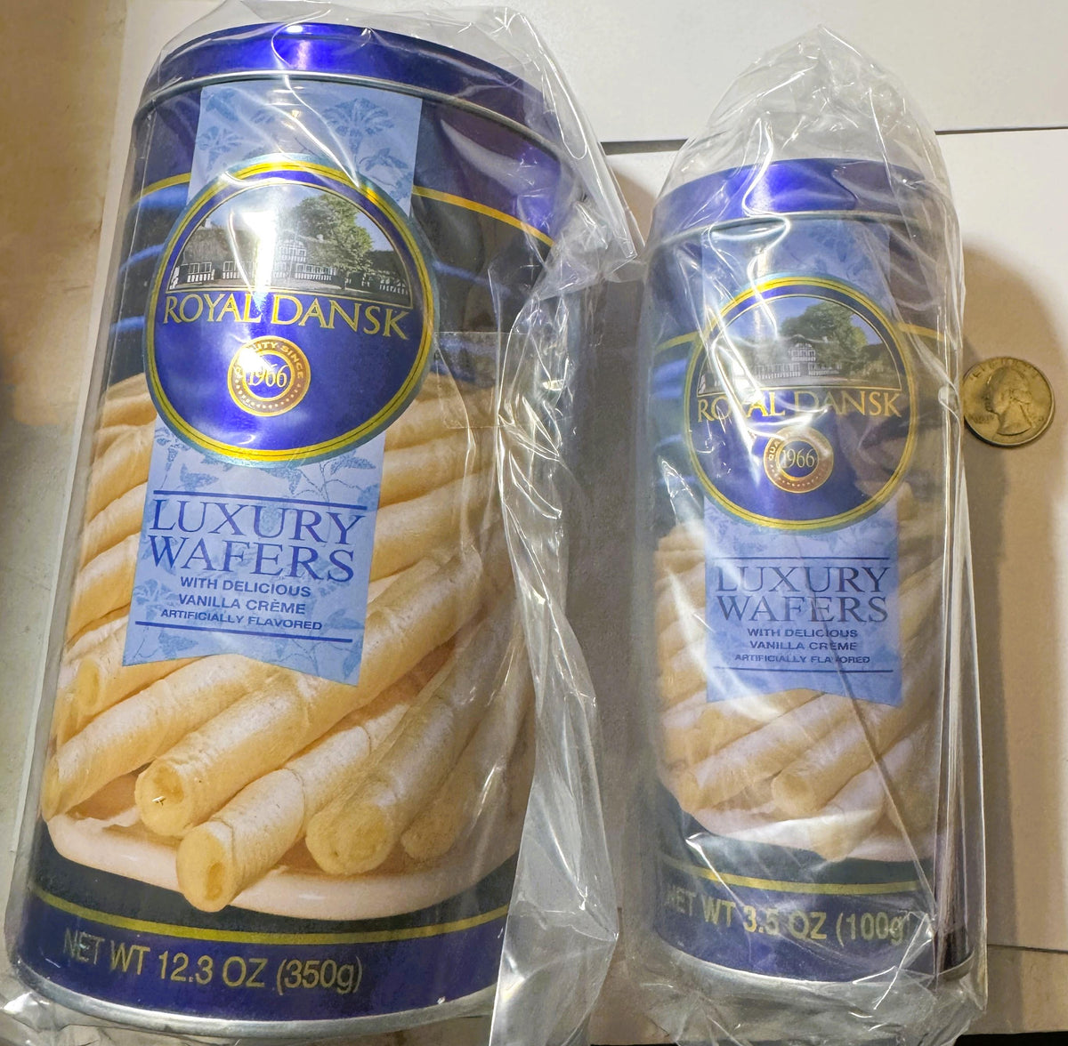 Two Royal Dansk luxury wafer boxes in blue packaging with vanilla crème filling, shown with a penny for scale against white b