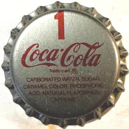 Vintage Coca-Cola bottle cap with red swirl logo and number 1, showing ingredients list on cream-colored metal surface