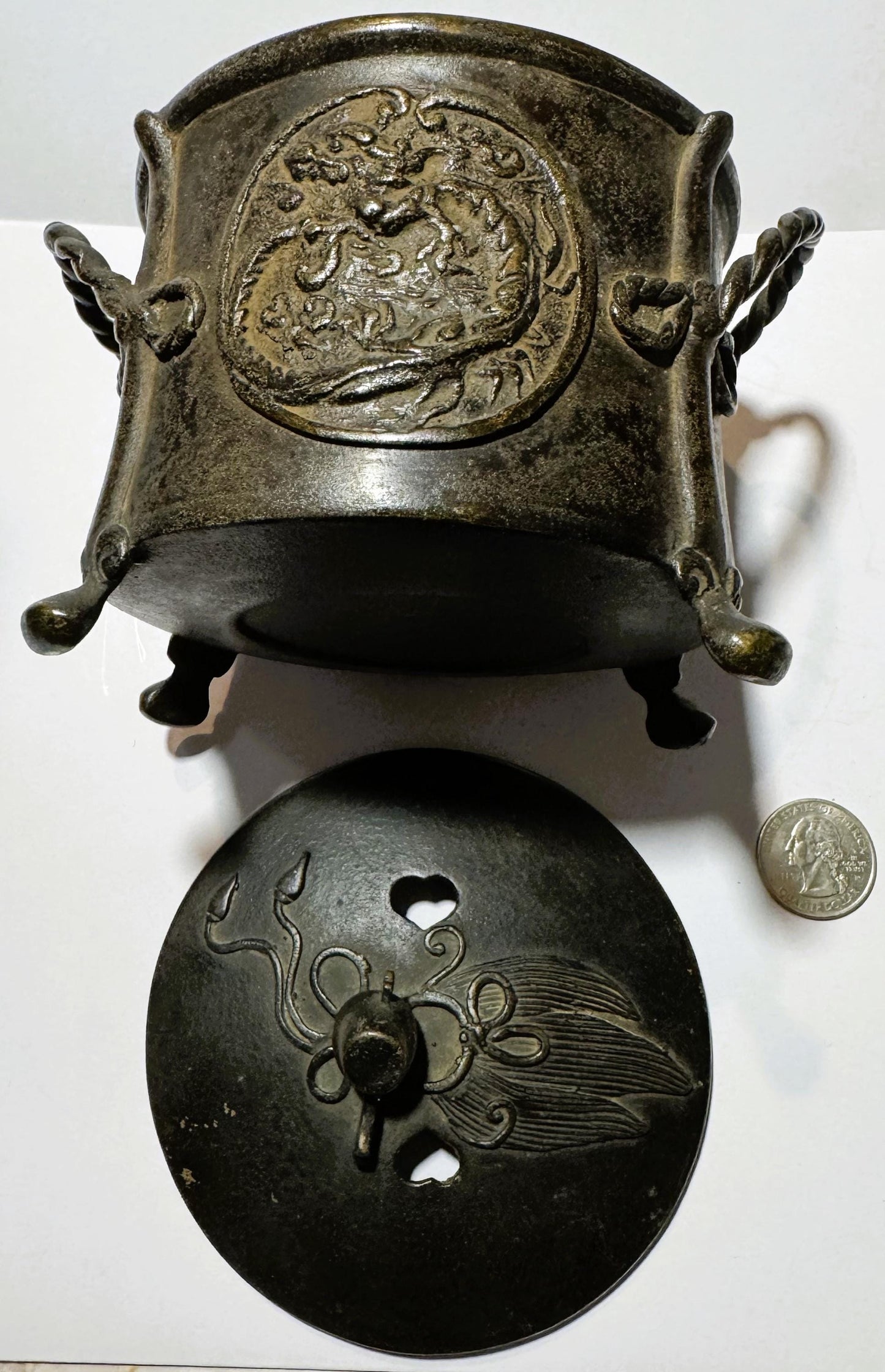 Two-piece bronze censer displayed separately with a US quarter coin for scale; upper piece shows dragon relief, lower piece f
