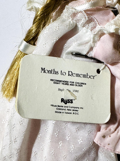 Close-up of product tag attached to vintage doll reading "Months to Remember" and "Russ" with style number 1592, made in Taiw
