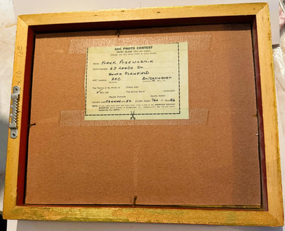 Back of framed photograph showing AHC Photo Contest entry blank filled out by Frank Przewoznik, with gold wooden frame and co