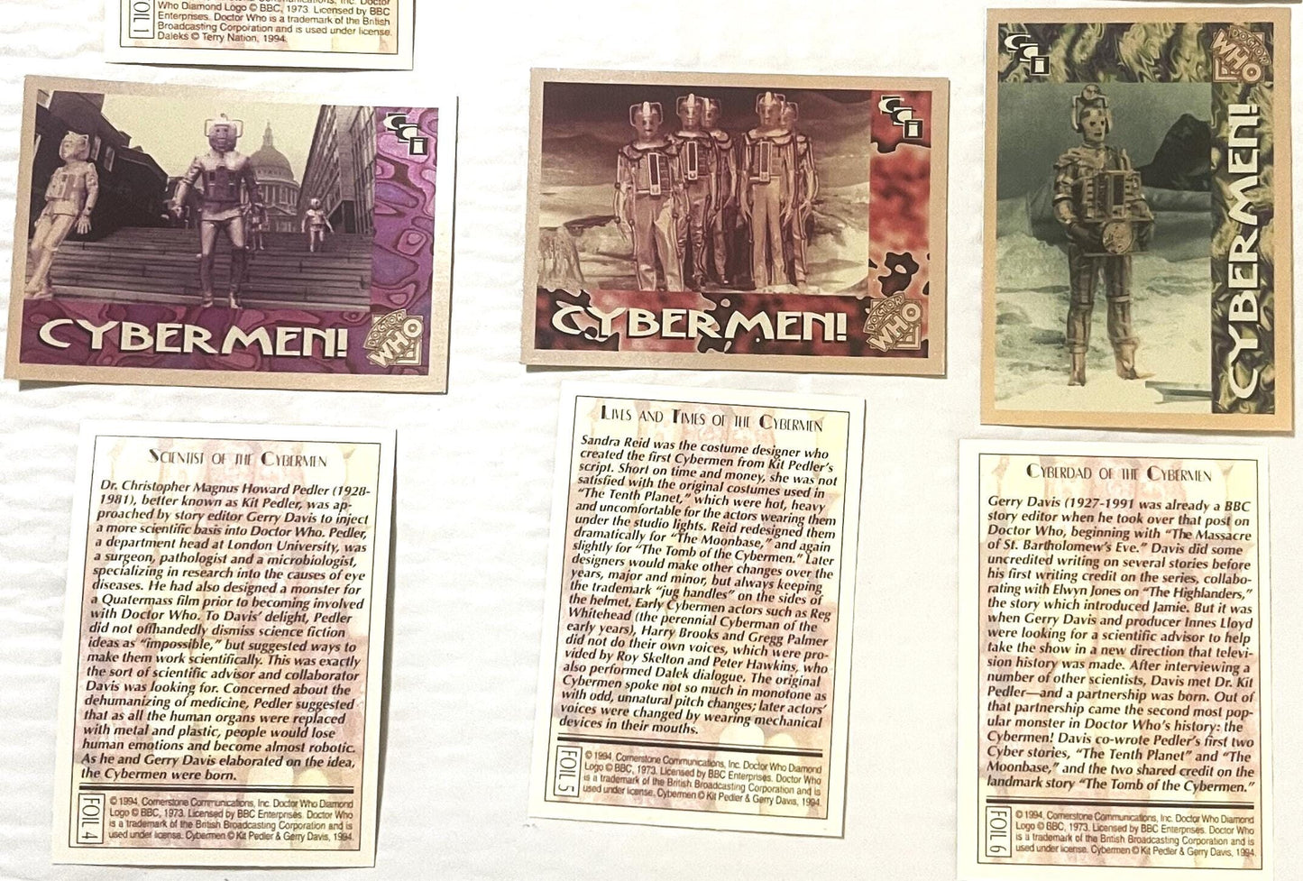 Three vintage 1994 Doctor Who Cybermen foil trading cards displayed flat, showing sci-fi scenes with armored figures and desc