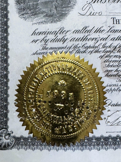 Gold embossed seal on antique bank stock certificate with decorative border and handwritten text visible behind it