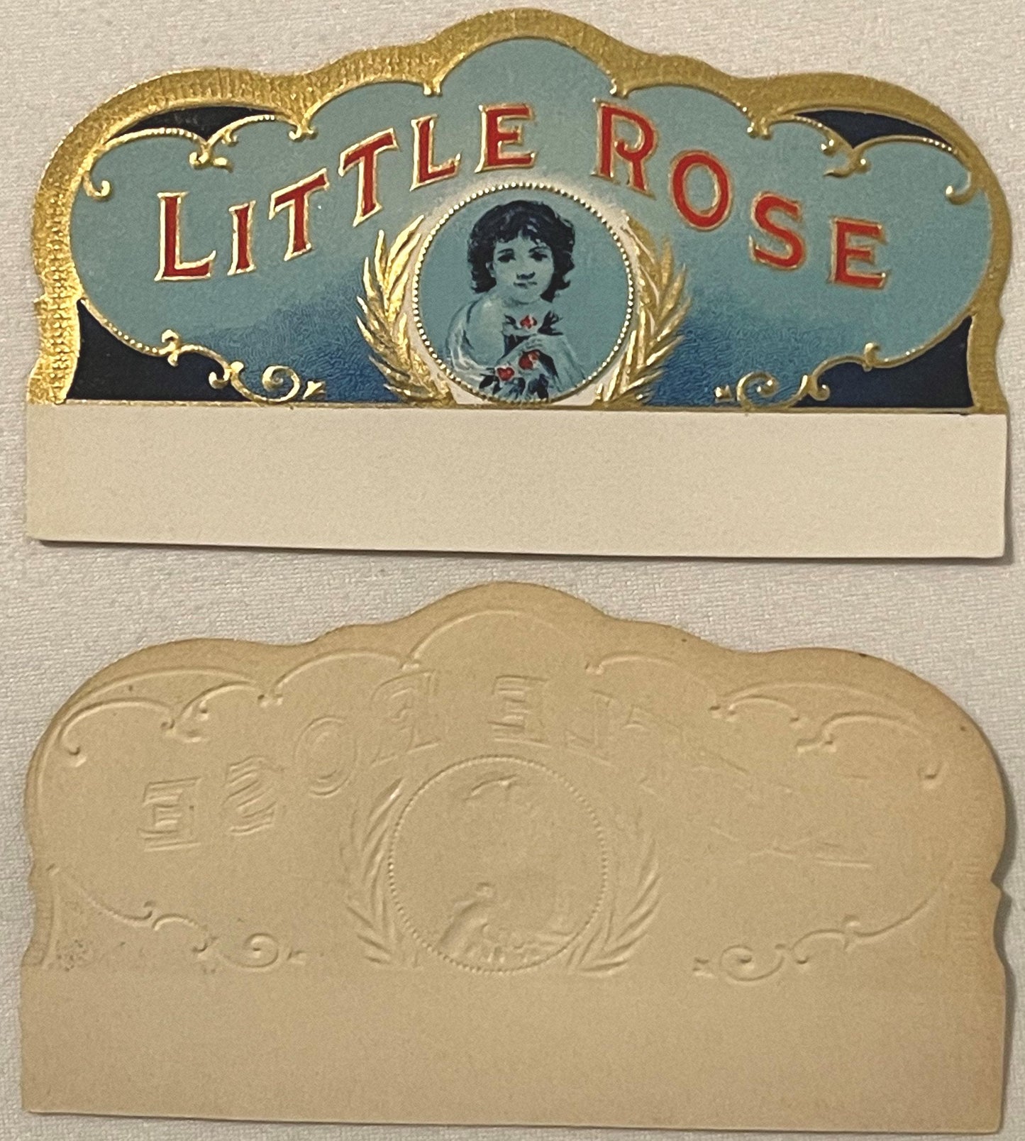 Two-piece antique cigar box label with gold embossed borders, blue top panel reading "LITTLE ROSE" in red letters with portra
