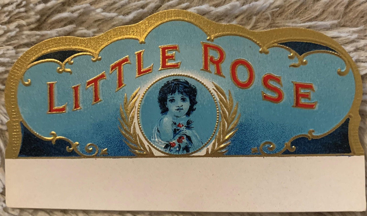 Ornate gold-embossed cigar box label with "Little Rose" in red letters, featuring a young woman's portrait in oval frame surr