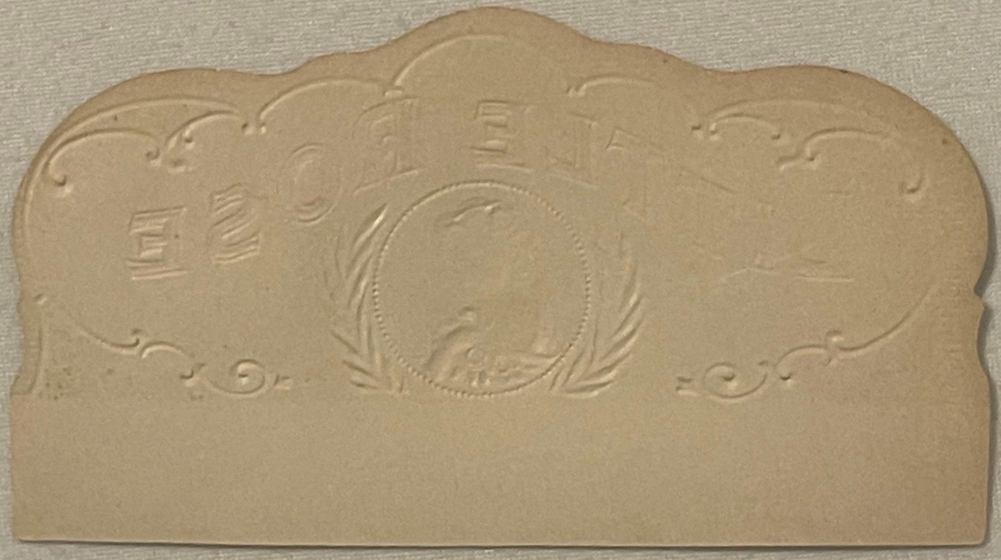 Cream-colored embossed cigar box label with central oval portrait surrounded by decorative flourishes and Asian characters, p