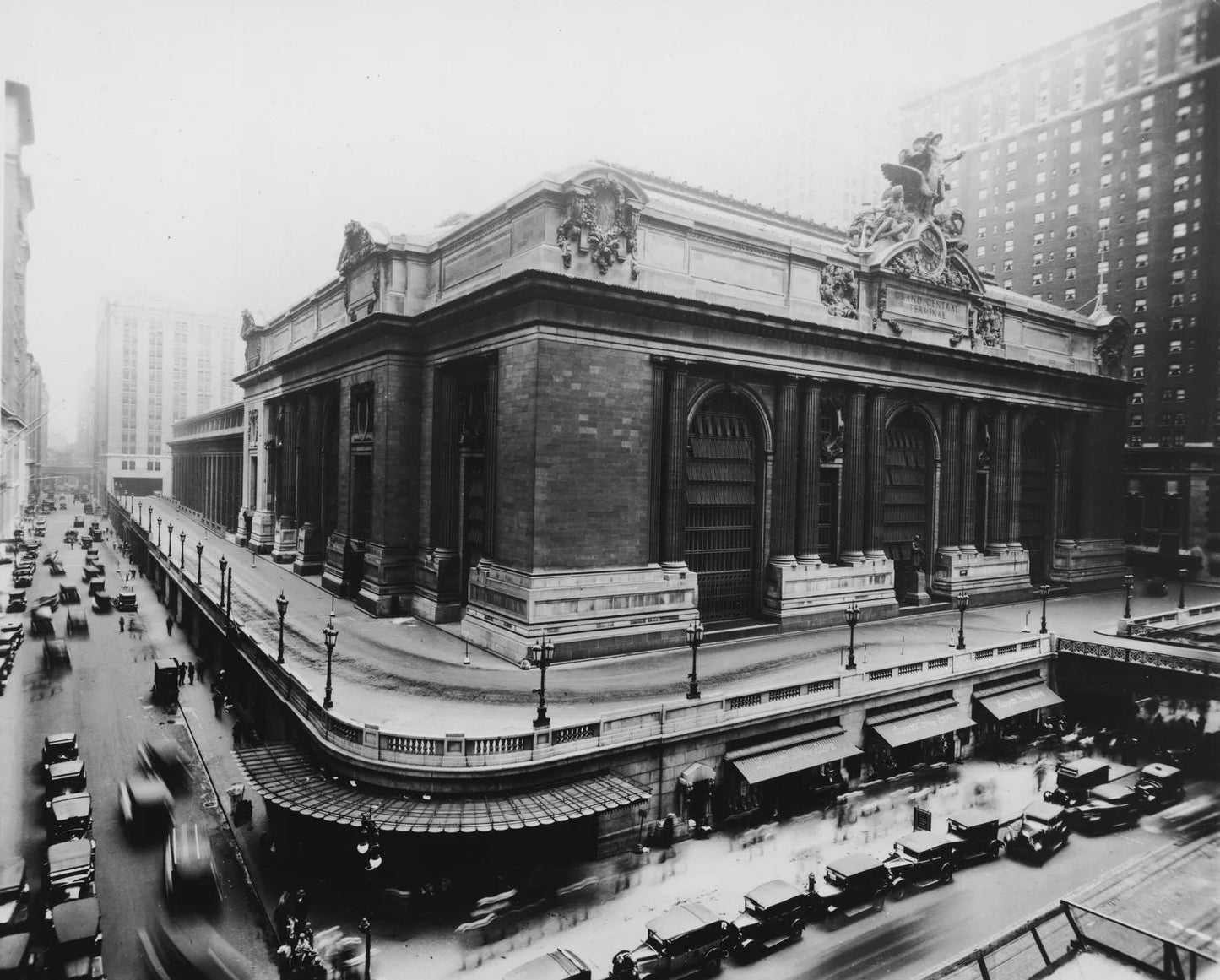 Black and white photograph of Grand Central Terminal's exterior, a beaux-arts building with ornate stonework and arched windo