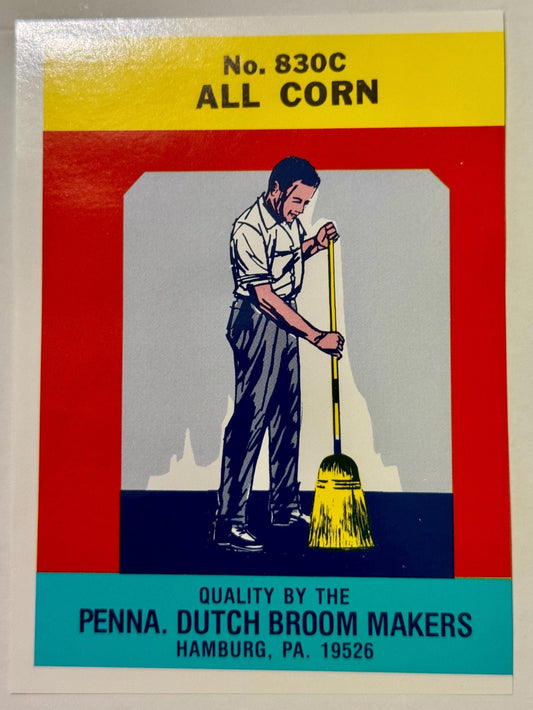 Vintage broom label with man holding yellow corn broom, red and yellow design.