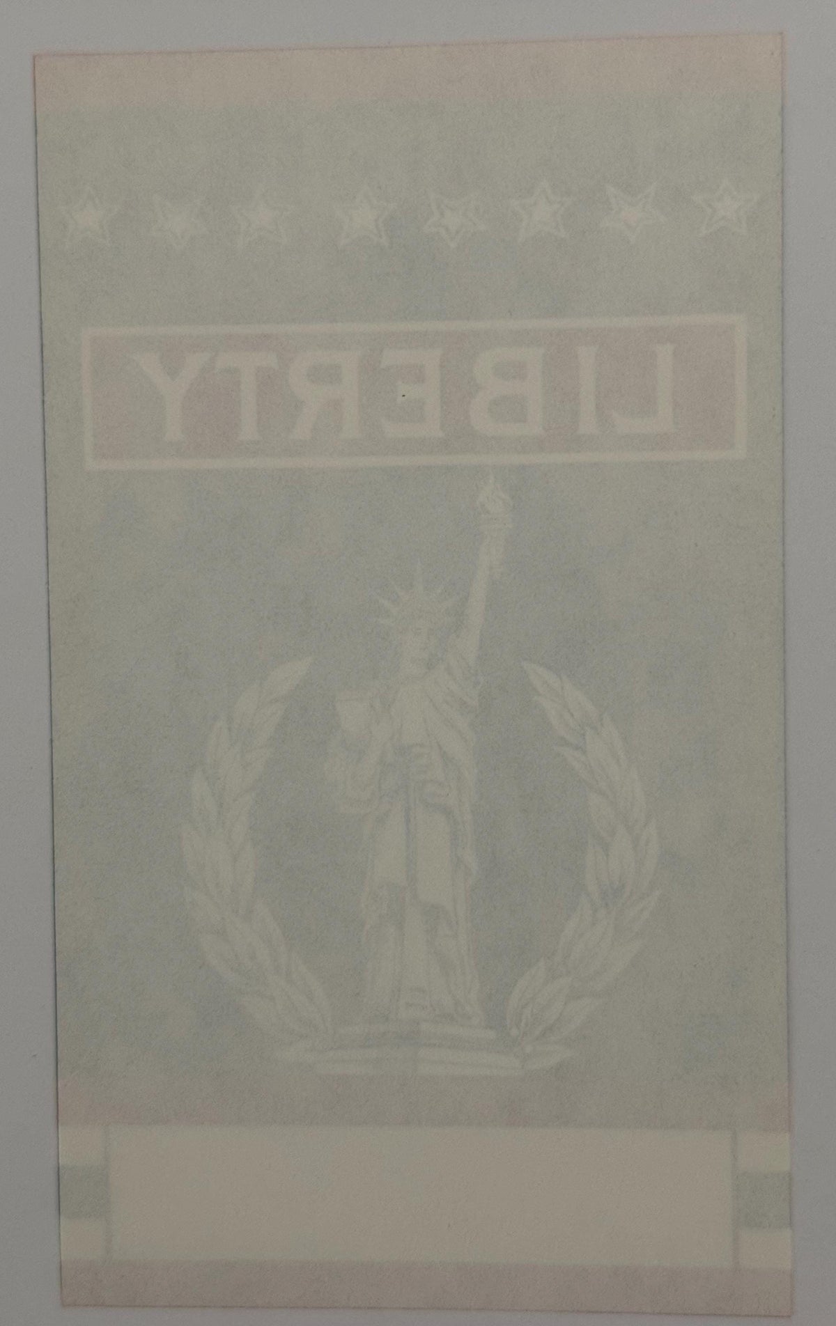 Antique broom label with faded Statue of Liberty image and "LIBERTY" text in embossed lettering on cream-colored paper