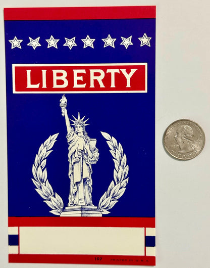 Vintage Liberty broom label with Statue of Liberty, eight stars, and laurel wreath on blue background, shown next to quarter 