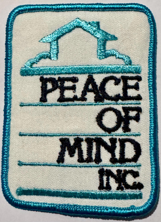 Peace of Mind Inc. embroidered patch: turquoise house outline over a cloud above black PEACE OF MIND INC. lettering on white twill, turquoise merrowed edge