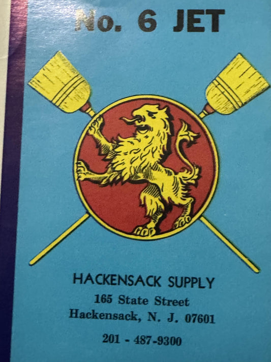 Upper part of the label: No. 6 JET in black above the crossed brooms and the lion on its red disc, the Hackensack Supply imprint below