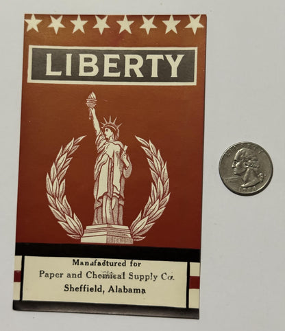 Front of the LIBERTY broom label beside a quarter for scale, Sheffield, Alabama imprint at the foot