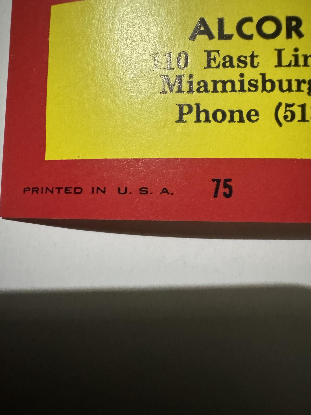 Close-up of the Alcor Supply imprint and the small PRINTED IN U.S.A. line with the number 75