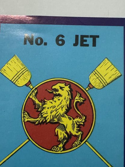 Close-up of the rampant lion on the red disc, mouth open and tail curled, the two straw brooms crossing behind it