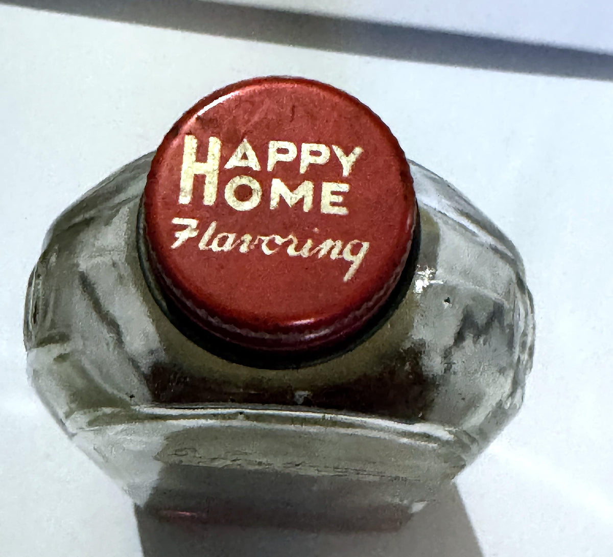 Red lithographed Happy Home Flavoring screw cap seen from above