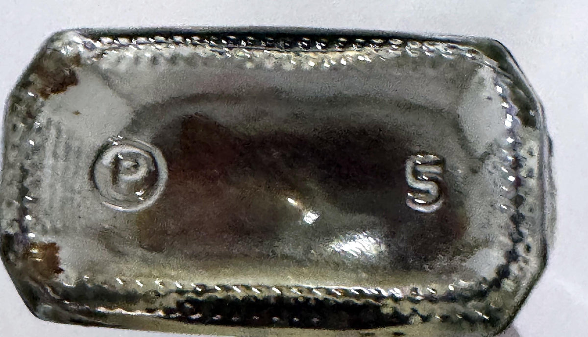 Embossed P in a circle and the number 5 on the base of the Happy Home vanilla bottle
