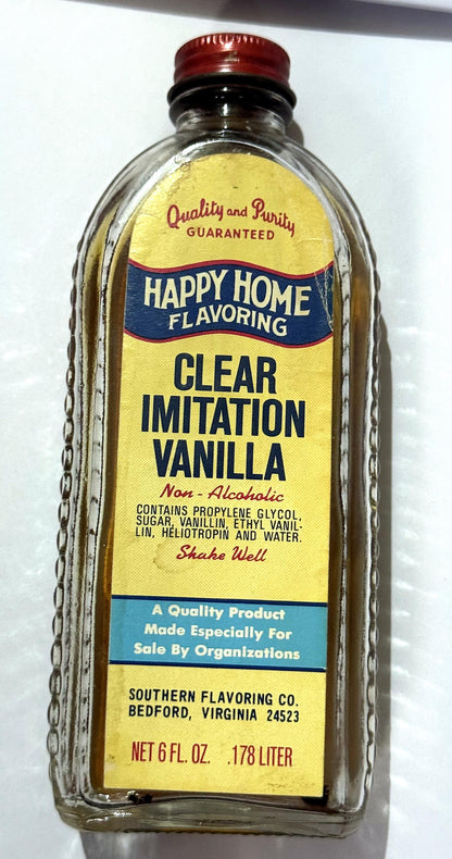 Vintage Happy Home Clear Imitation Vanilla bottle from Southern Flavoring Co. of Bedford, Virginia, with its red Happy Home cap