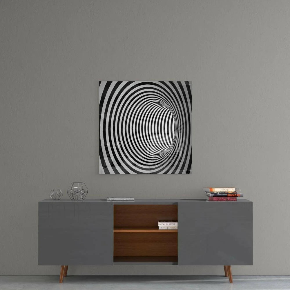 Black and white mesmerizing spiral optical illusion glass wall art on gray wall
