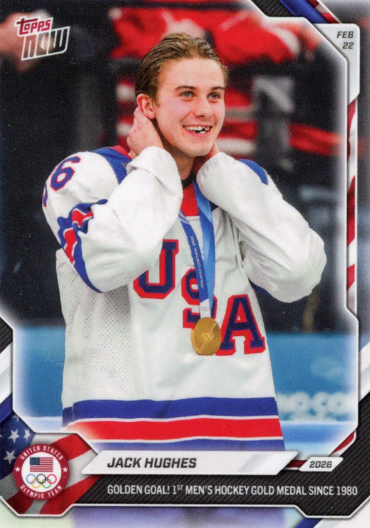 Jack Hughes wears Team USA white hockey jersey with gold medal, smiling at camera against blurred red background.