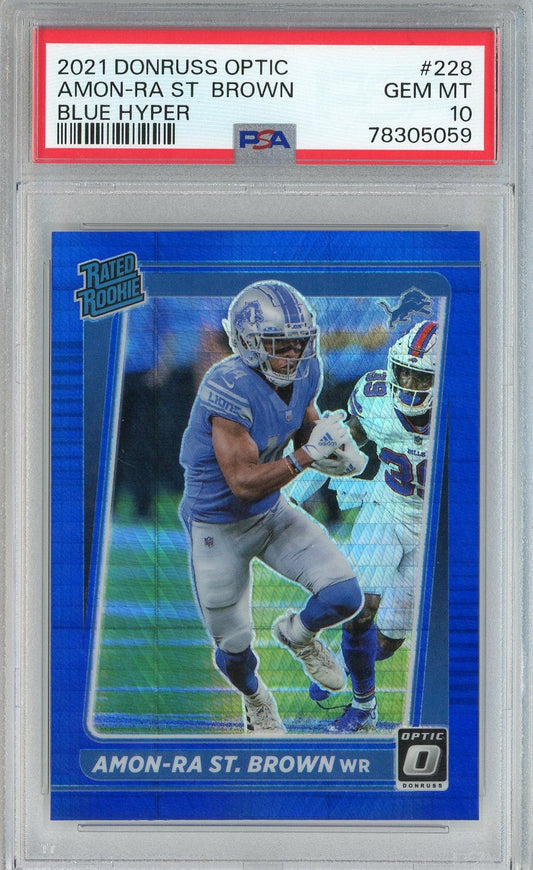 PSA-graded card in clear holder displaying blue Donruss Optic rookie card of football player Amon-Ra St. Brown in Lions uniform with label visible on top.