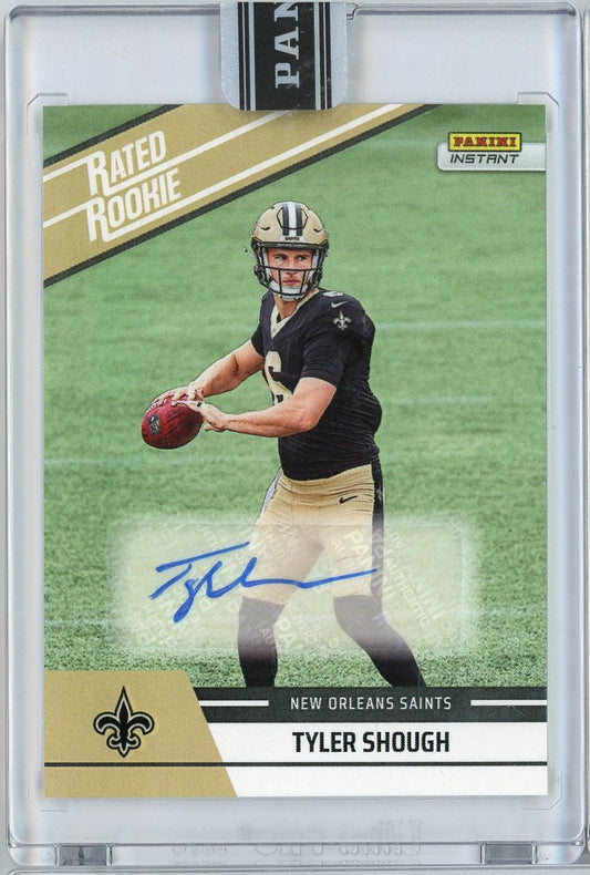 Front of graded football card showing Tyler Shough in New Orleans Saints black jersey holding red football, with blue autograph and gold "Rated Rookie" banner.