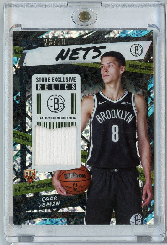 Front of graded basketball card showing Egor Demin in Brooklyn Nets black jersey holding Wilson basketball with white relic swatch.