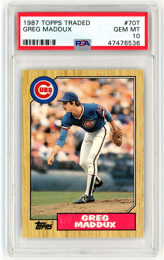PSA-graded 1987 Topps Traded Greg Maddux rookie card in clear holder showing front with wood-grain border and player fielding photo.