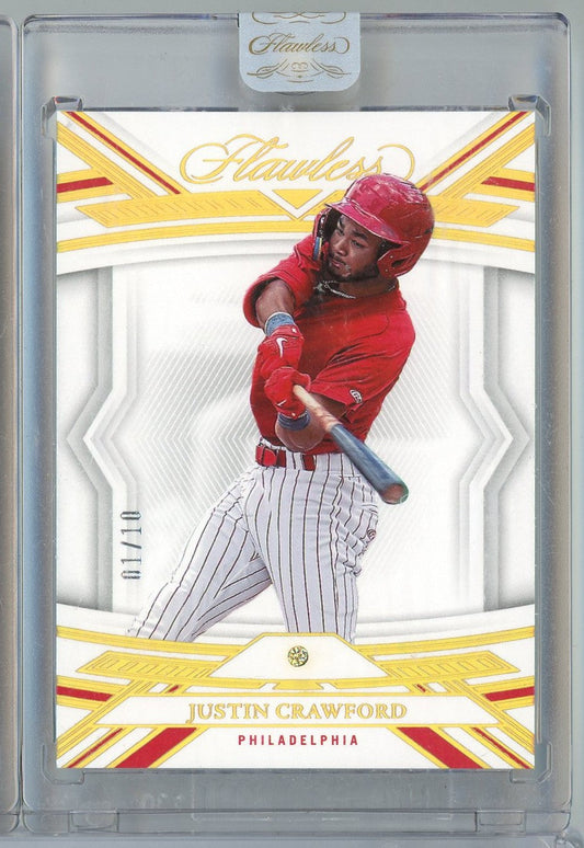 Front of 2023 Panini Flawless Justin Crawford rookie baseball card showing player in red Philadelphia Phillies uniform mid-swing, numbered 11/110, encased in protective plastic holder.