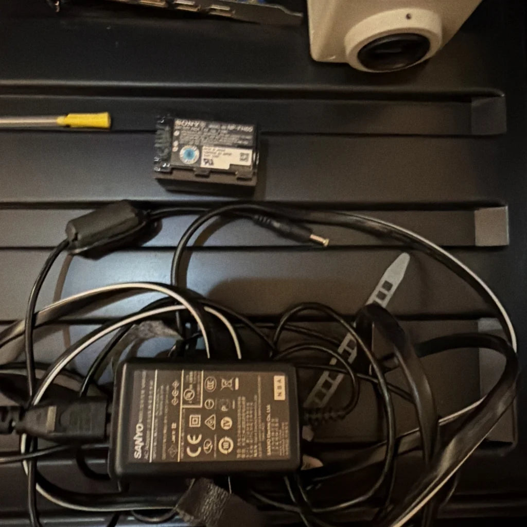 Black Sony NP-F730 battery on cords in machine vision camera control unit