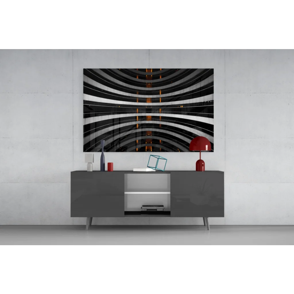 Black and white glass wall art with orange glow accents on gray table
