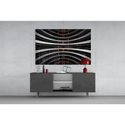 Black and white glass wall art with orange glow accents on gray table