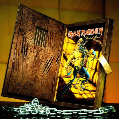 Iron Maiden Piece of Mind album art by Rantz Hoseley on distressed open book display