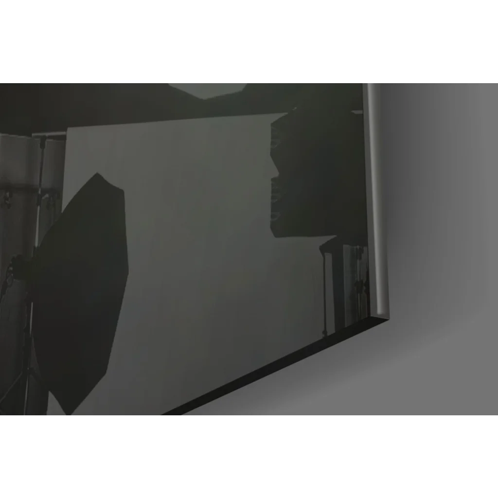 Sleek silver-framed glass wall art reflecting studio lighting equipment