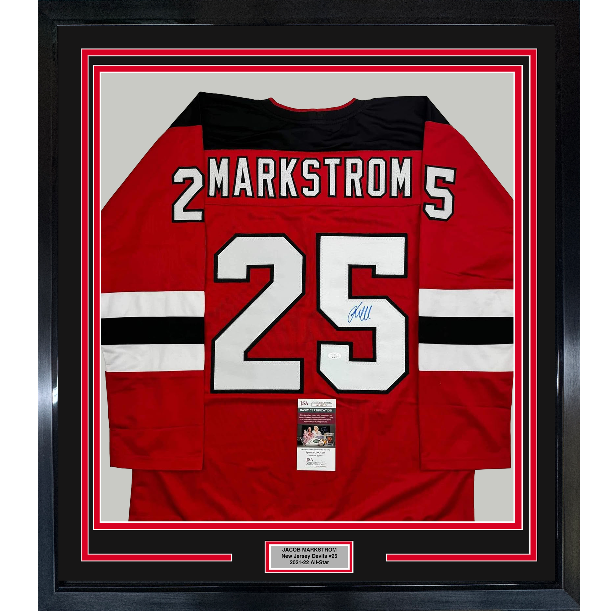 Red New Jersey Devils hockey jersey #25 with "MARKSTROM" nameplate, signed in blue ink, displayed in black frame with JSA certification.
