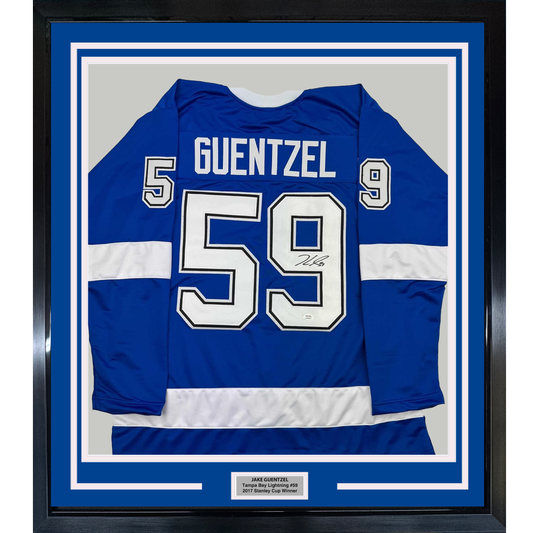 Framed blue Tampa Bay Lightning jersey number 59 with "GUENTZEL" nameplate, signed, displayed flat against white matting with identifying nameplate below.