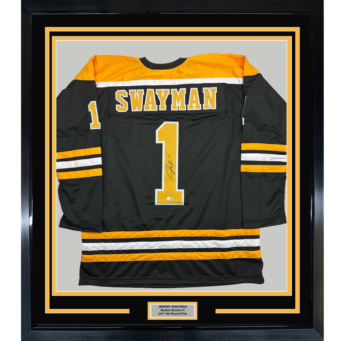 Framed black Boston Bruins hockey jersey number 1 with "Swayman" printed on back, displayed front-facing with gold and white striping, mounted in black frame with nameplate.