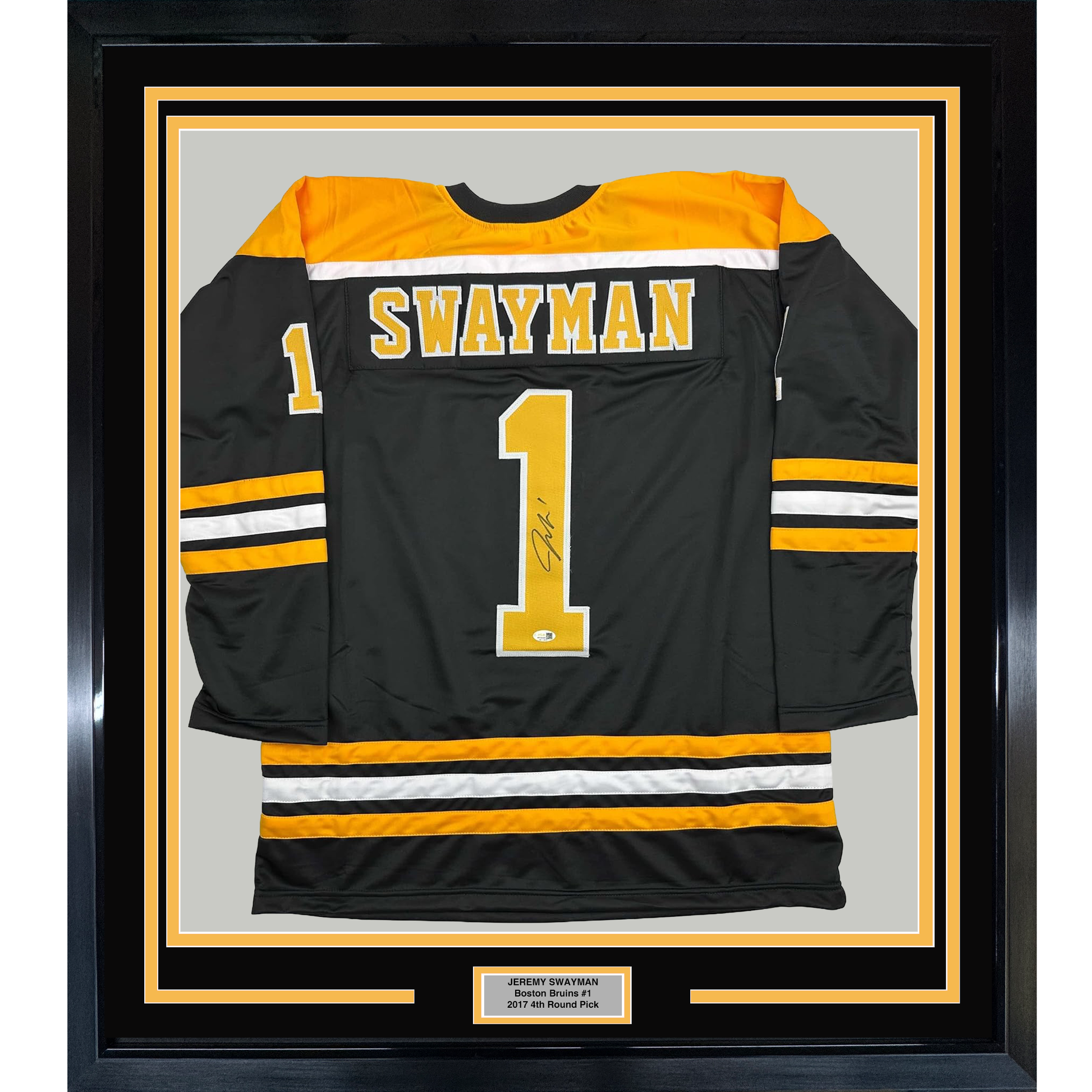 Framed black Boston Bruins hockey jersey number 1 with "Swayman" printed on back, displayed front-facing with gold and white striping, mounted in black frame with nameplate.