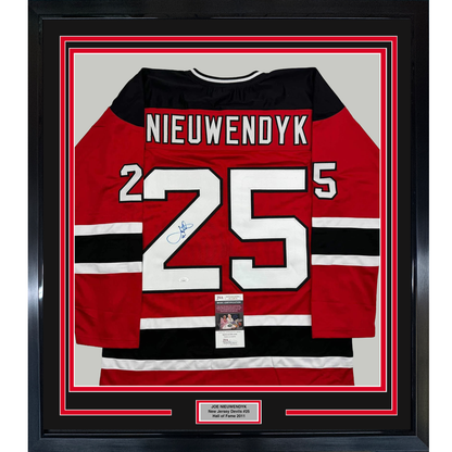 Framed red, black, and white New Jersey Devils hockey jersey #25 signed by Joe Nieuwendyk with JSA authentication certificate visible.